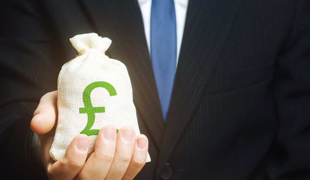 Man in suit holding a back of money