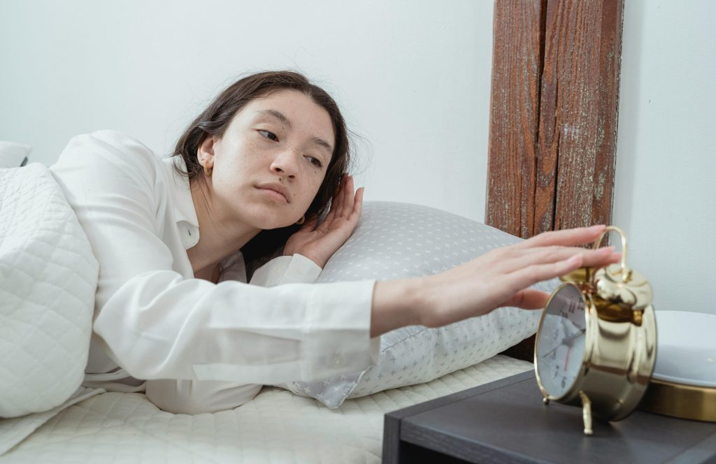 Woman in bed disabling the alarm